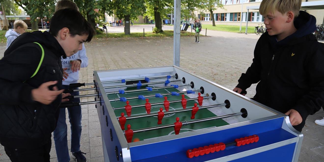 speelplaats met leerlingen aan kickertafel 
